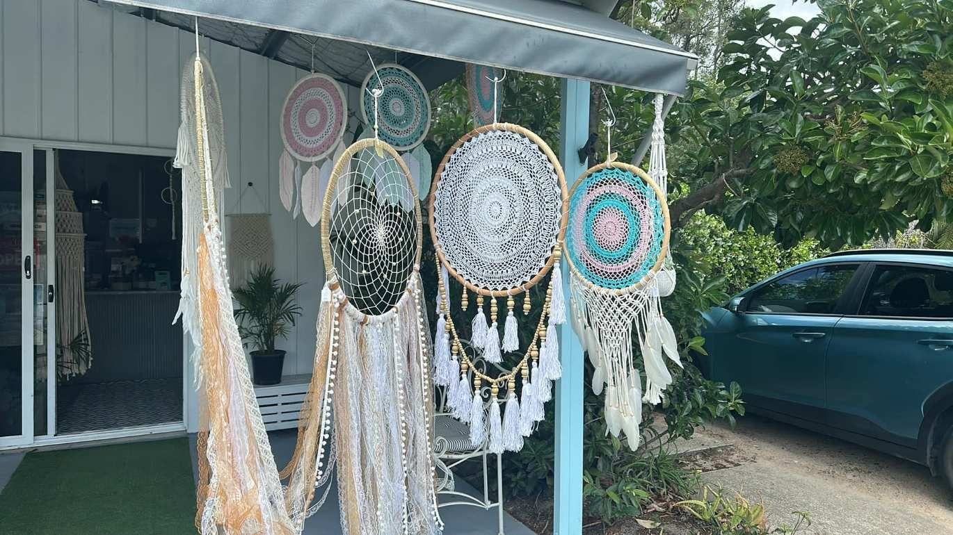 A Bunch Of Dream Catchers Are Hanging From A Pole Outside Of A Building — Ivy & Ash Flowers & Gifts in Palmview, QLD