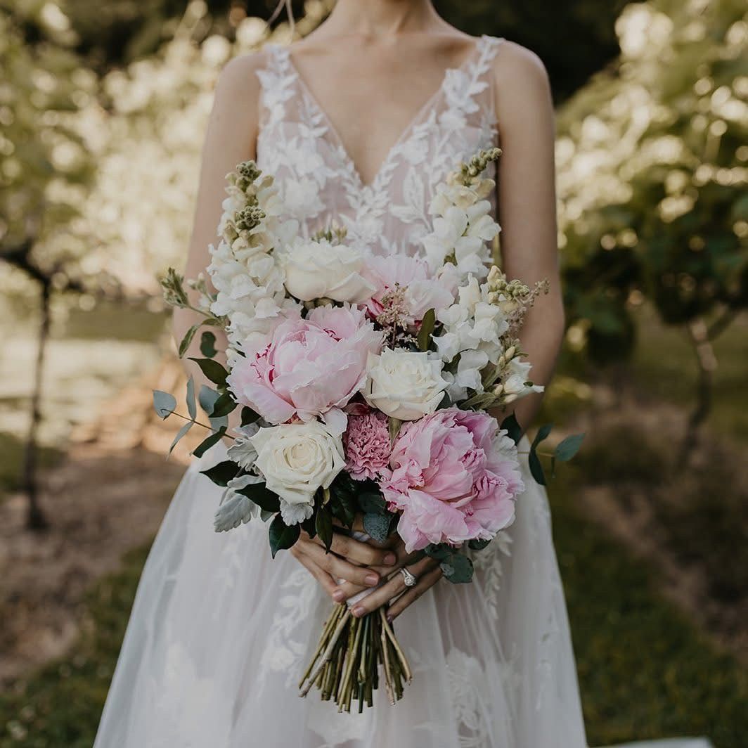A Bride In A White Dress Is Holding A Bouquet Of Pink And White Flowers — Ivy & Ash Flowers & Gifts in Palmview, QLD