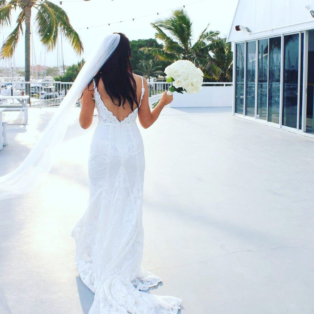 A Girl In A Wedding Dress Holding White Flowers In Her Right Hand — Ivy & Ash Flowers & Gifts in Palmview, QLD