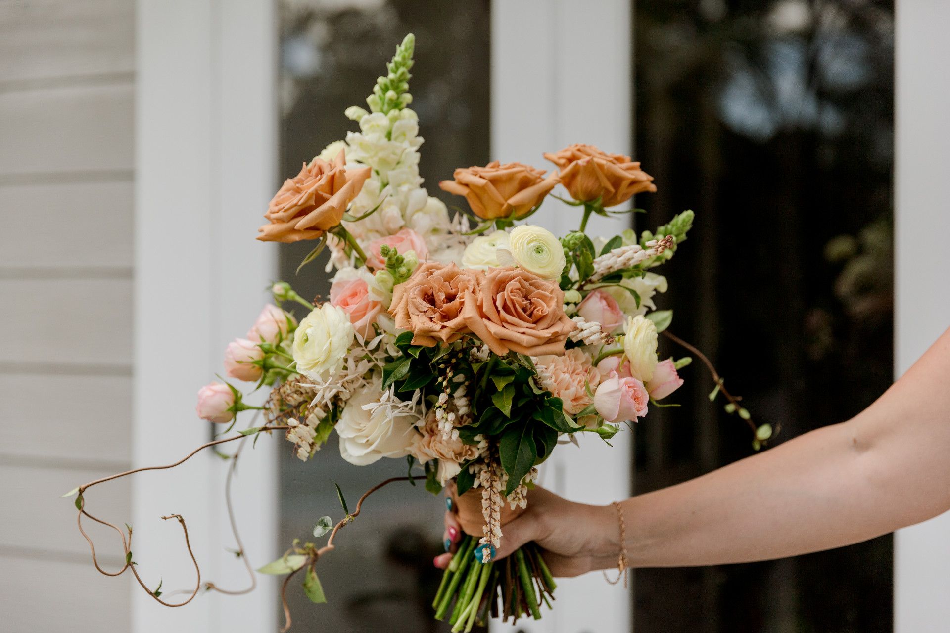 A Lady's Hand Holding A Bunch Of Wedding Flowers — Ivy & Ash Flowers & Gifts in Palmview, QLD