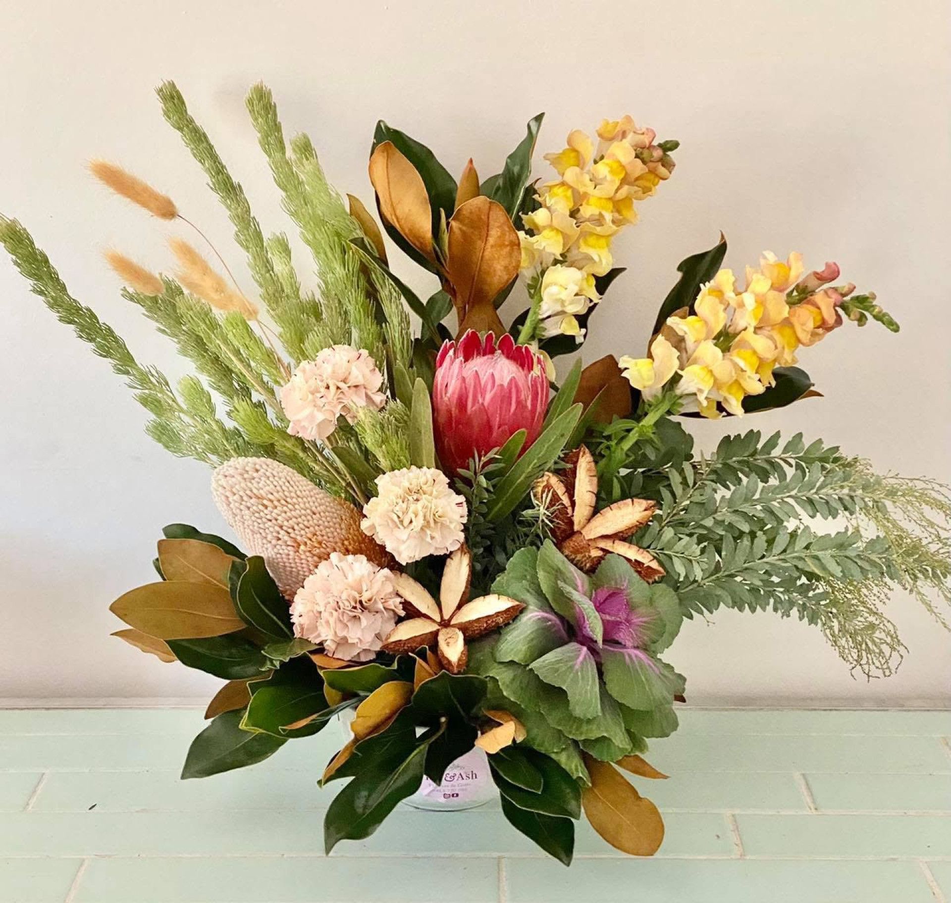A Bouquet Of Flowers Is Sitting On A Table Next To A Car Key — Ivy & Ash Flowers & Gifts in Palmview, QLD