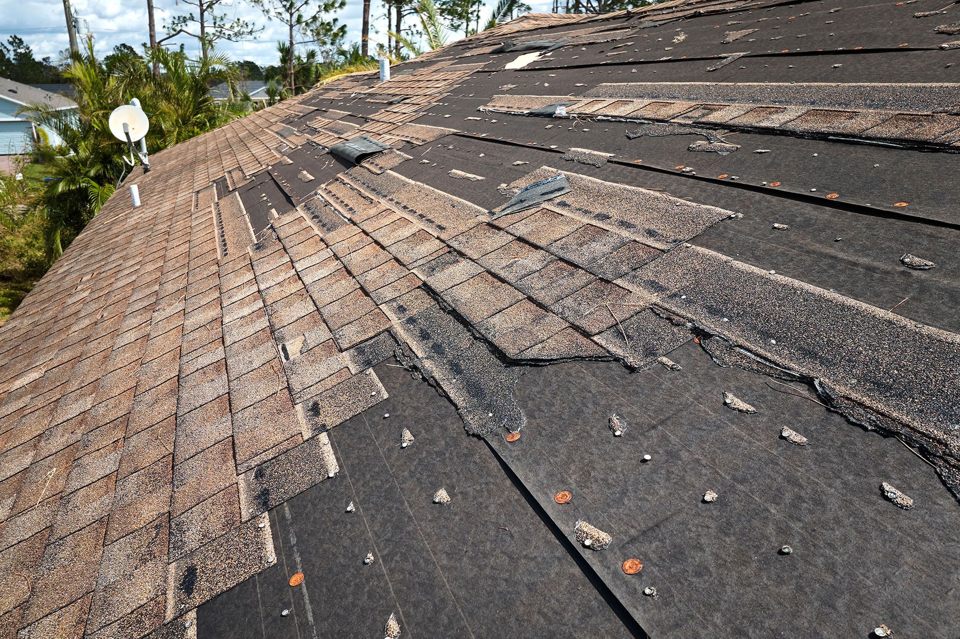 A close up of a roof with a satellite dish in the background.