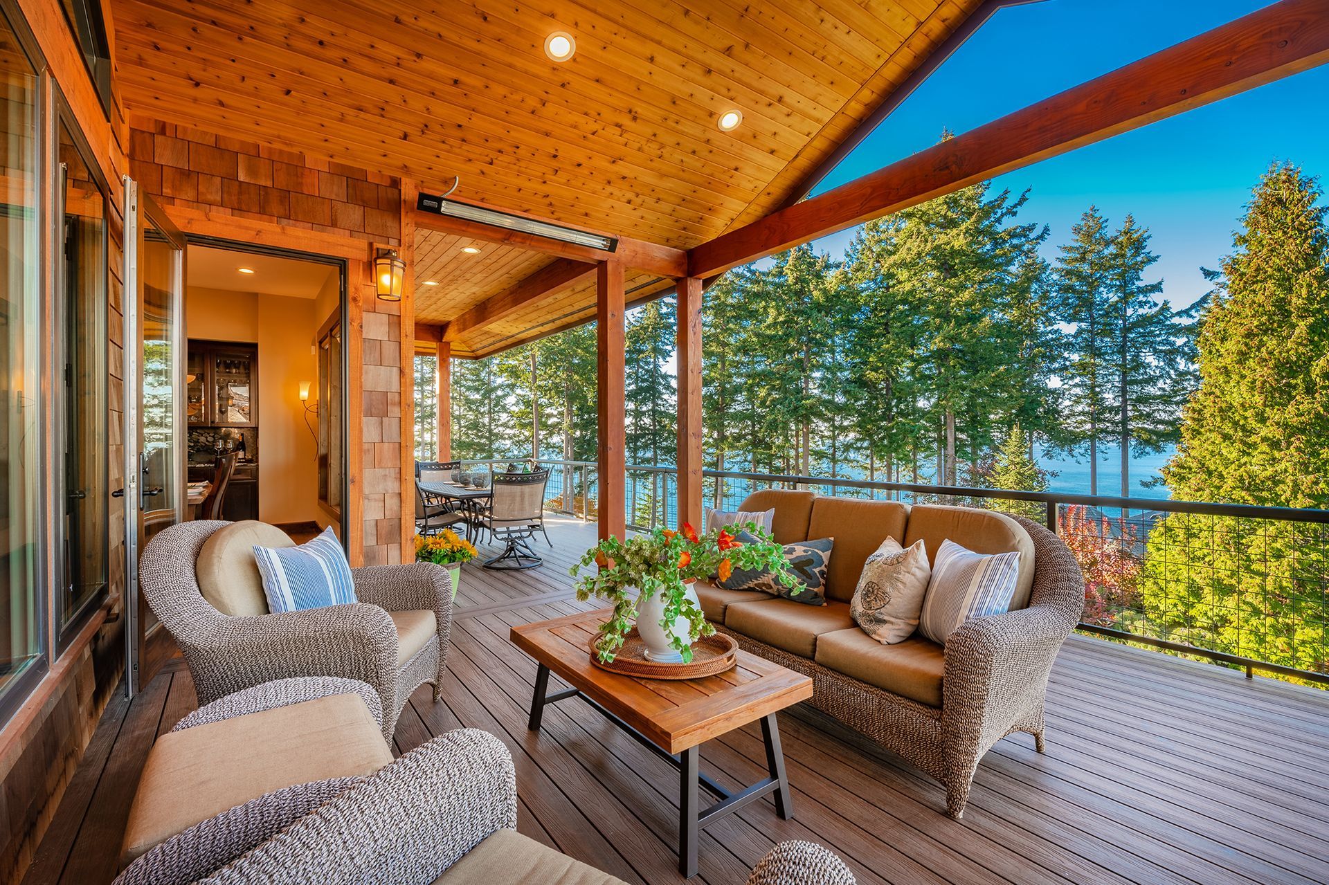 A large deck with a couch , chairs , and a table.