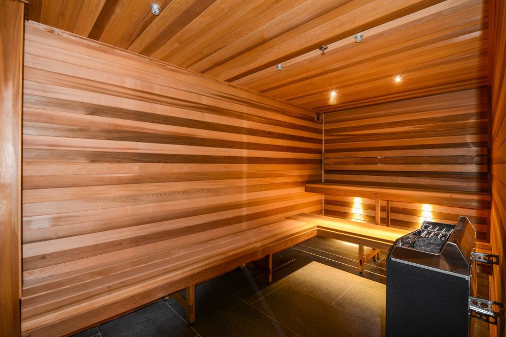 Wooden sauna interior with bench seating and heater.