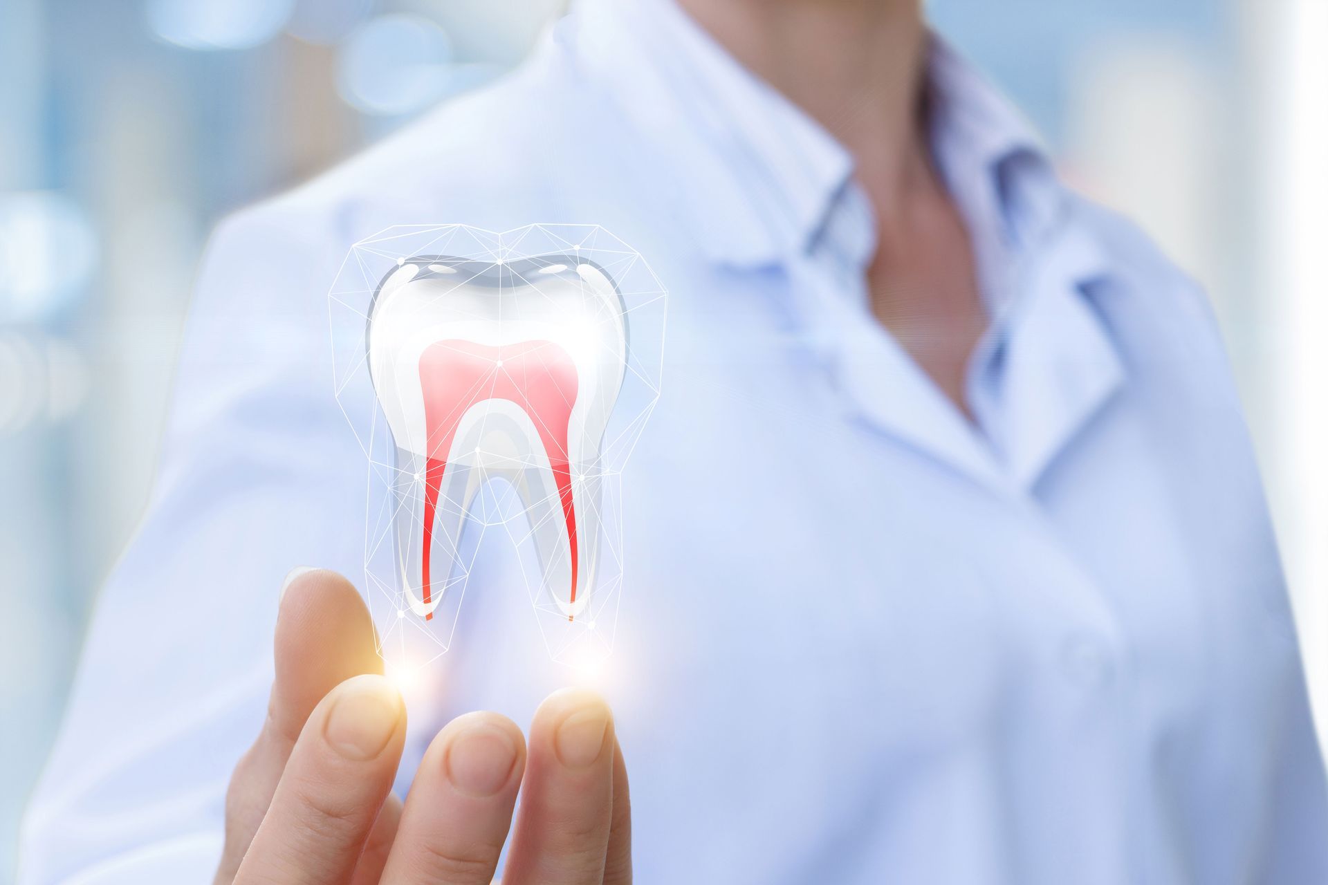 A dentist holding a holographic tooth illustration representing emergency dentistry in Kokomo, IN, a