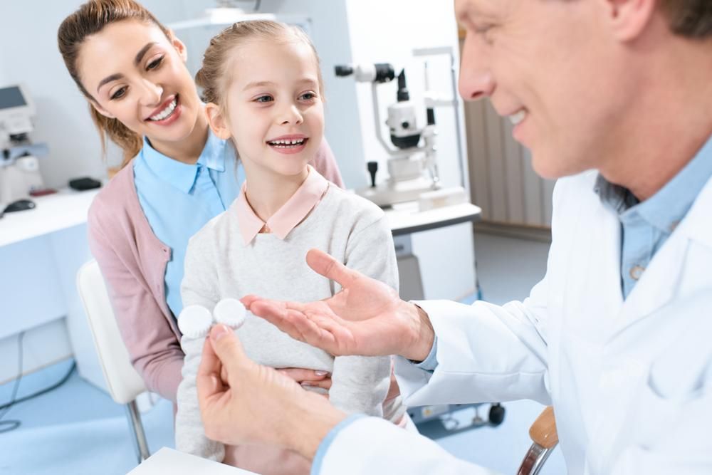 A Doctor Is Giving A Little Girl A Pair Of Contact Lenses — Eyedentity Optical In Earlville, QLD