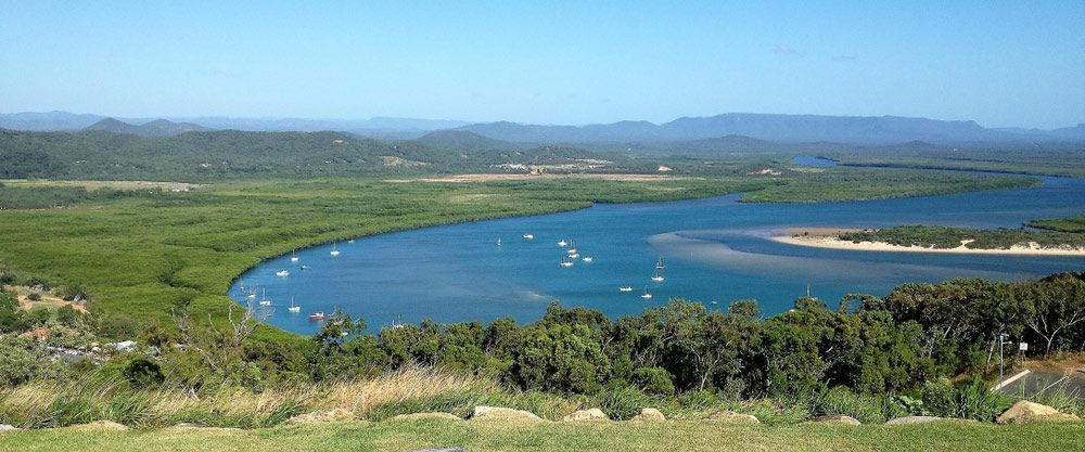 A View of a River With Boats in It and Mountains in the Background β Eyedentity Optical in Cooktown, QLD
