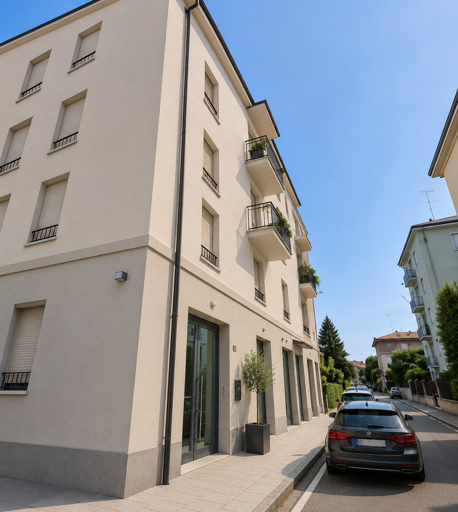 Stretta via cittadina accanto a un palazzo beige, con auto parcheggiate sotto un cielo azzurro.