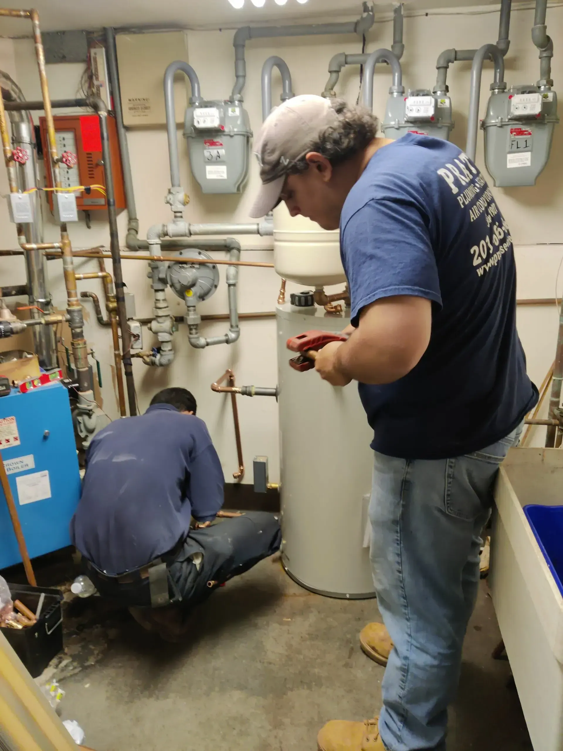 A man wearing a blue shirt that says ' plumbing ' on it