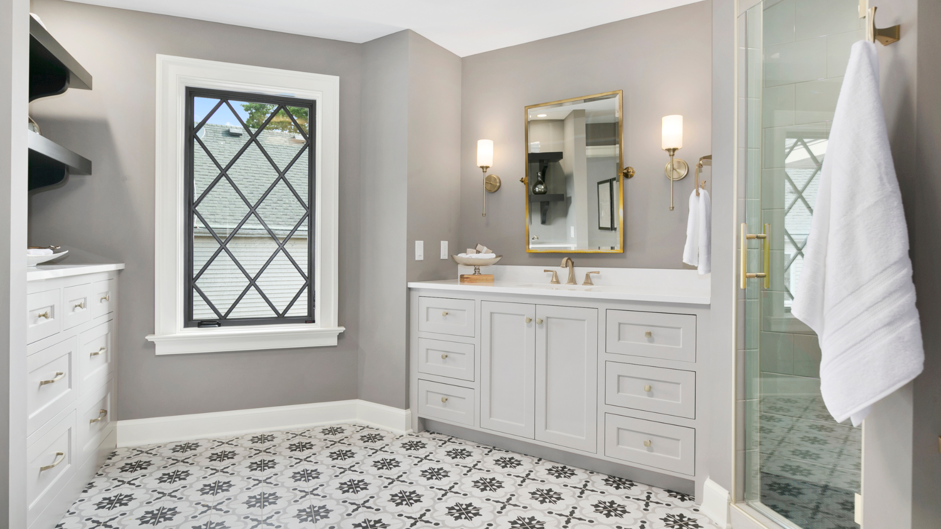 A bathroom with a sink , mirror , and window.