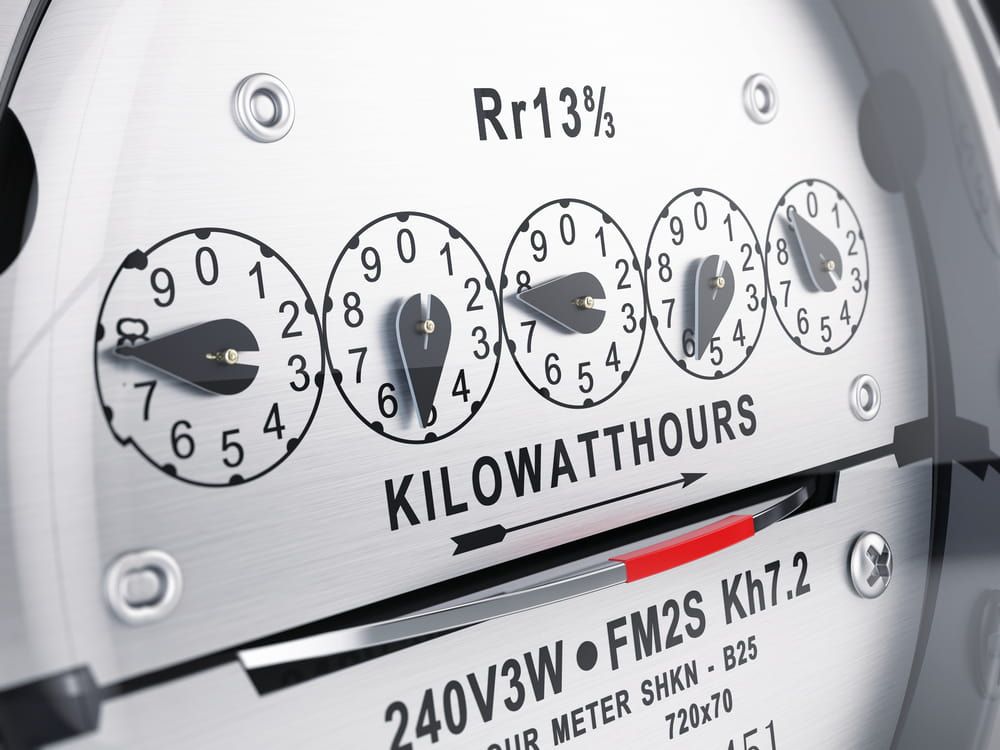 Close-up of a silver electric meter showing five circular dials indicating kilowatt-hour usage.