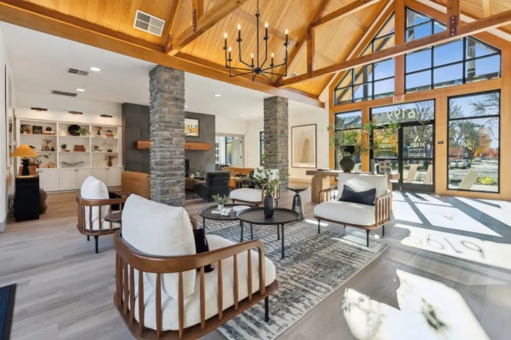 Lobby with high ceilings, exposed beams, stone pillars, seating area, and large windows at The Avery at Orenco Station, offers apartments for rent in Hillsboro, OR.