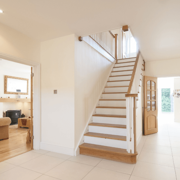 Freshly painted white staircase with wooden steps in a hallway