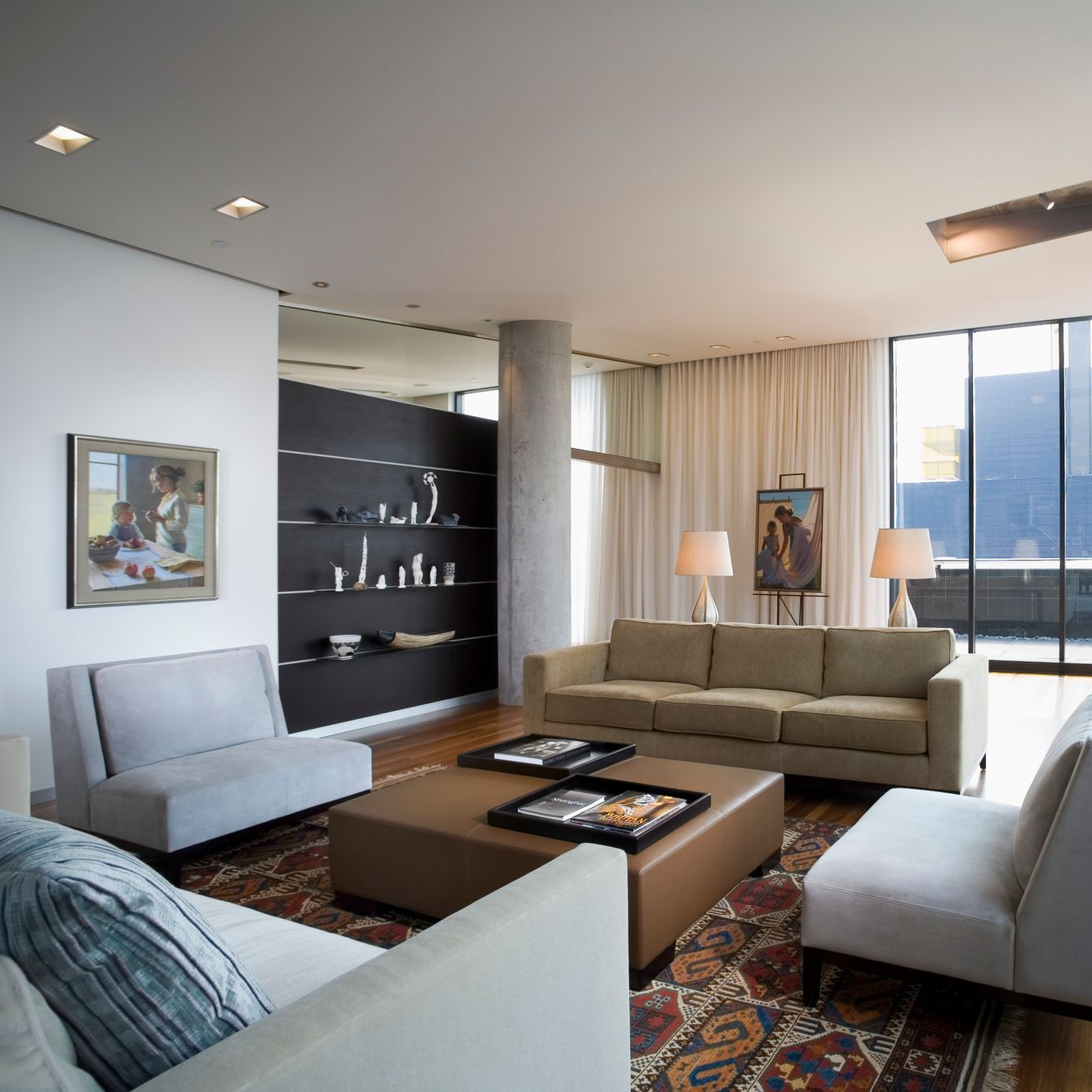Modern living room with beige couches, art, and a patterned rug.
