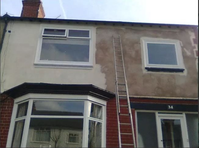 a house with a ladder on the side of it whilst exterior being repainted