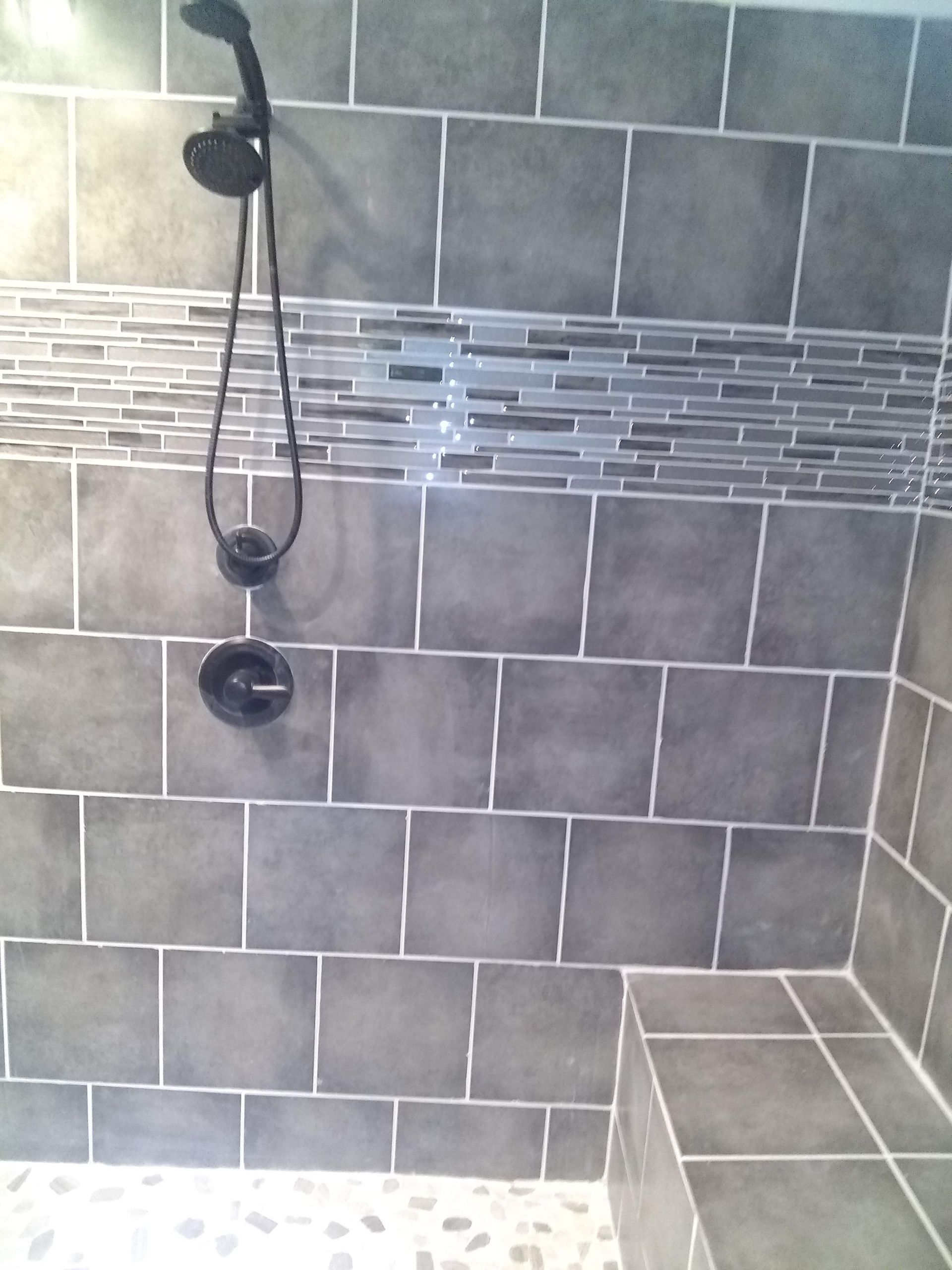 A bathroom with a tub , shower , sink and window.