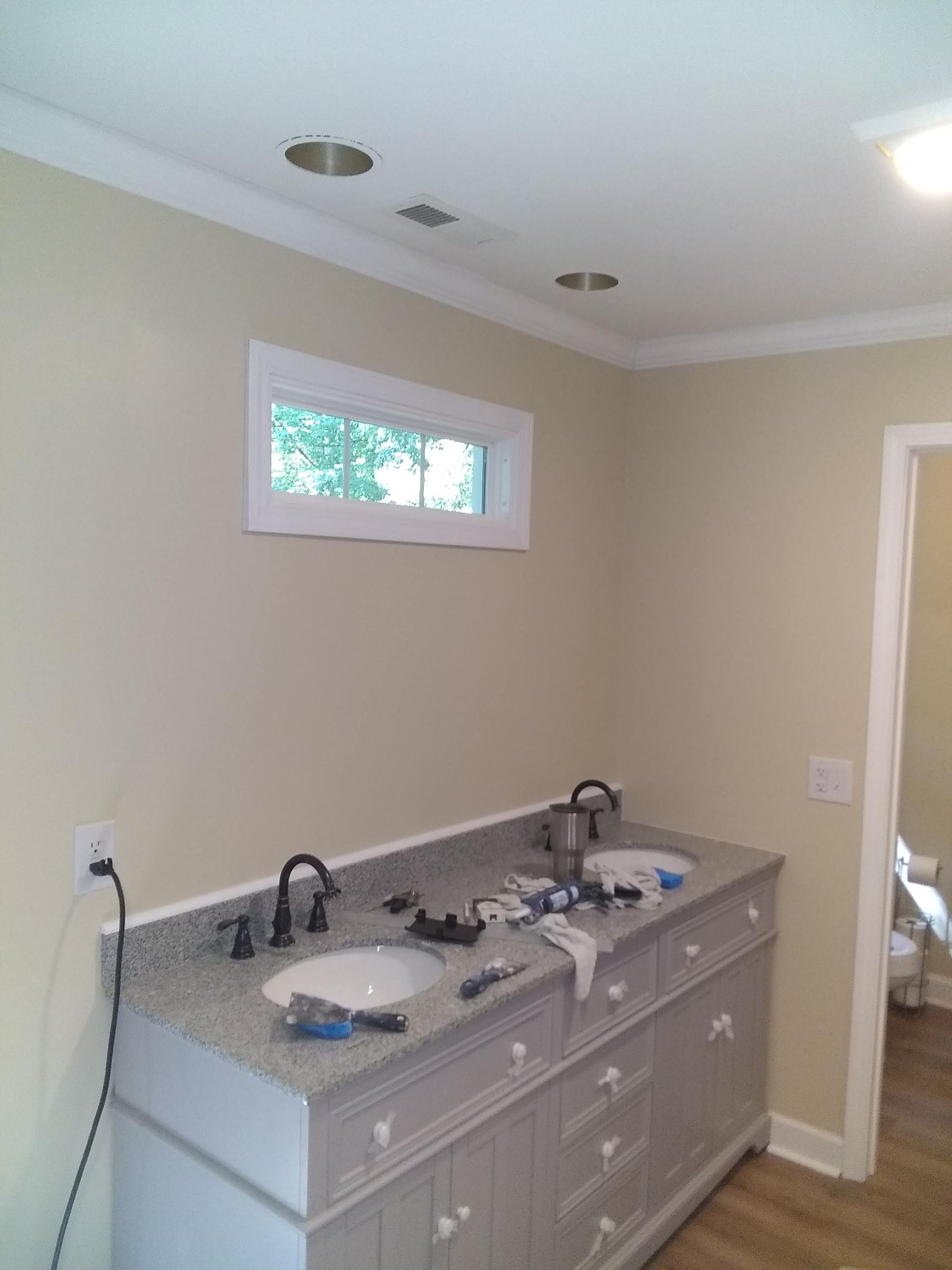 A man is installing a window with a drill.