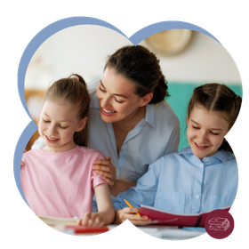Een vrouw helpt twee kinderen met knutselen aan een tafel; ze lachen allemaal in een lichte kamer.