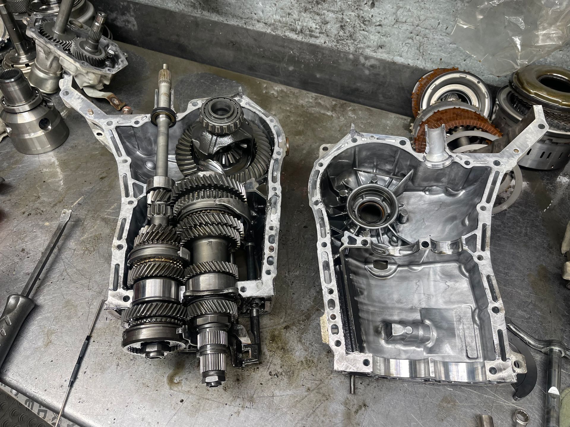 Mechanic installing clutch assembly in a car. Hands in gloves, holding tool and working on parts.