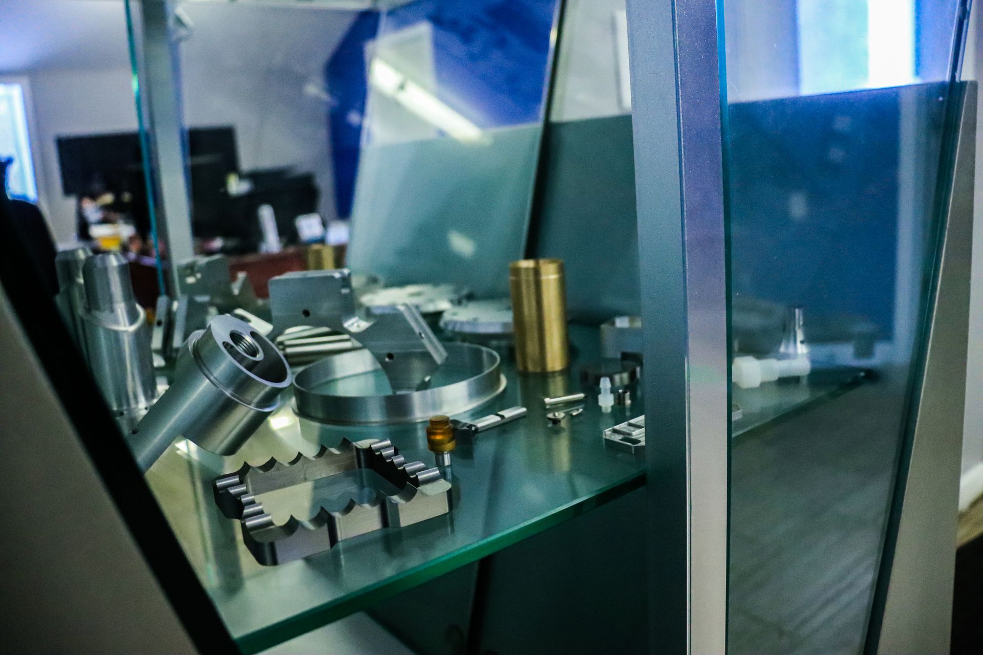 A glass display case filled with a variety of metal parts.