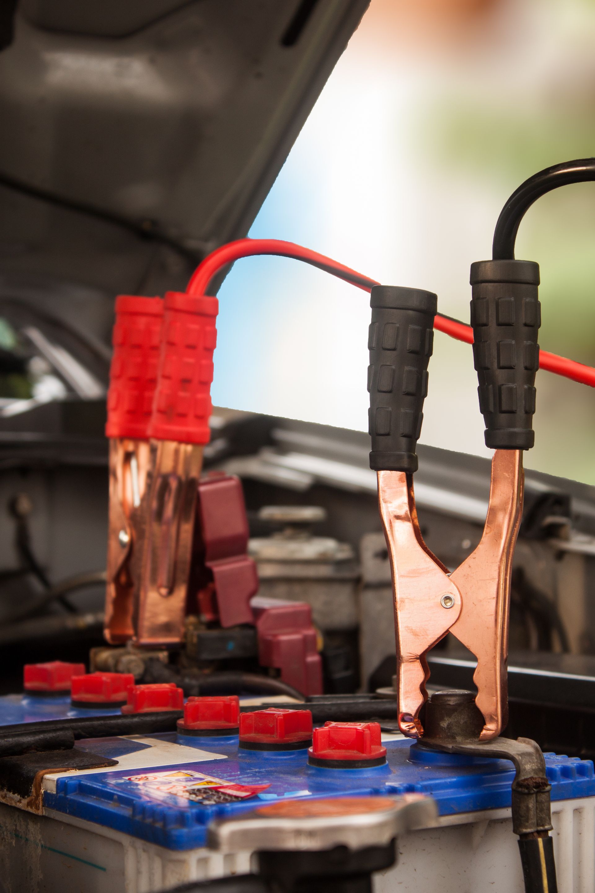 A car battery is being charged with jumper cables. | 299 Automotive Repair Longview, TX