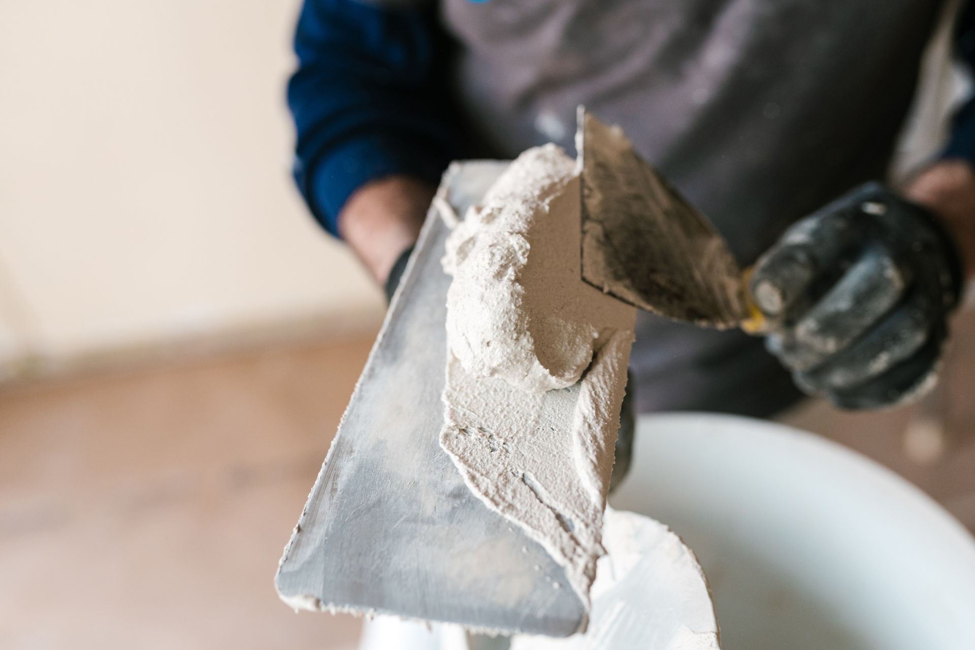 A carpenter putting plaster on a trowel.