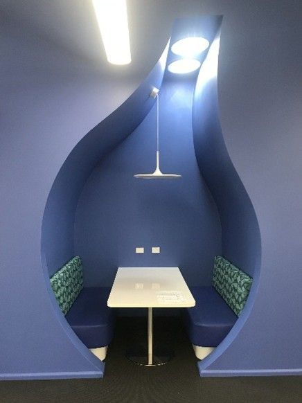 Curved plasterboard booth with built-in seating and modern lighting.