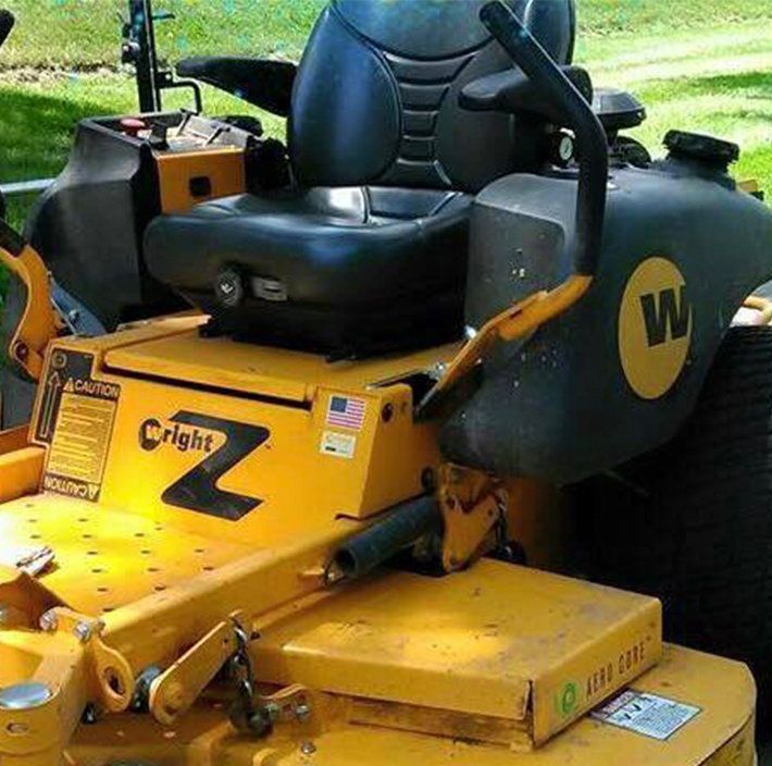 A yellow cright z lawn mower is parked in the grass