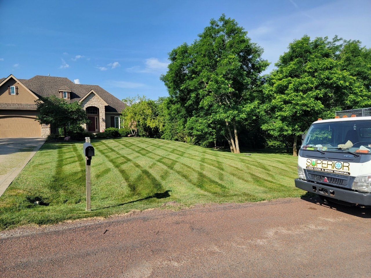 A white truck is parked in front of a lush green lawn.
