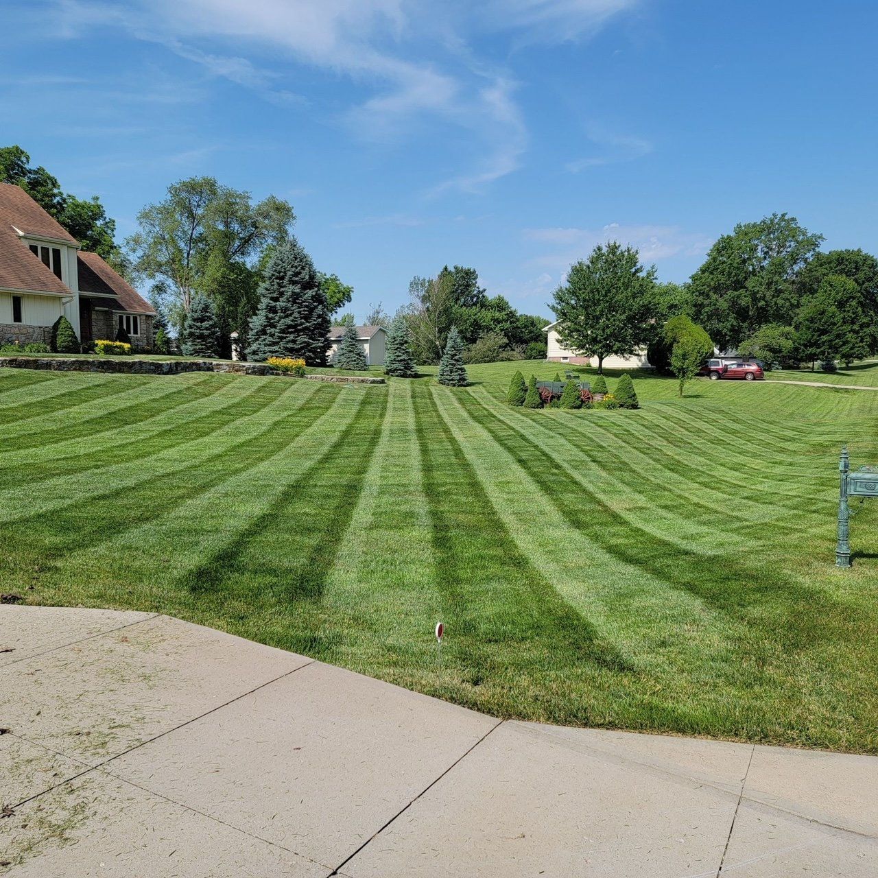 A lush green lawn with a house in the background