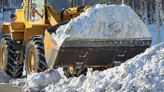 A bulldozer is clearing snow from the road.