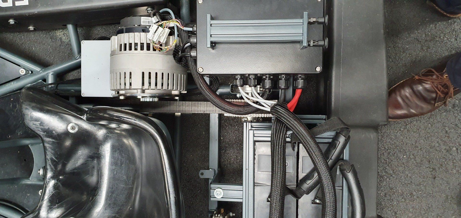 A close up of a car engine with a person standing next to it