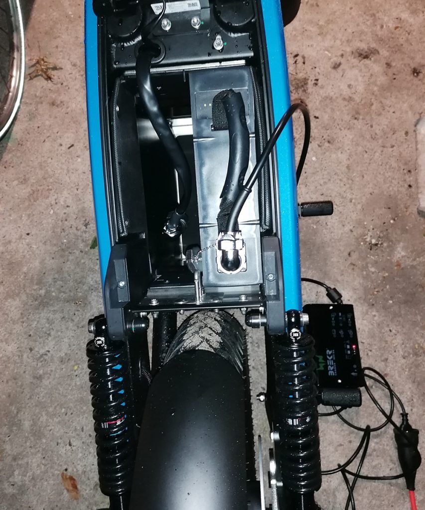 A blue and black motorcycle with a charger attached to it
