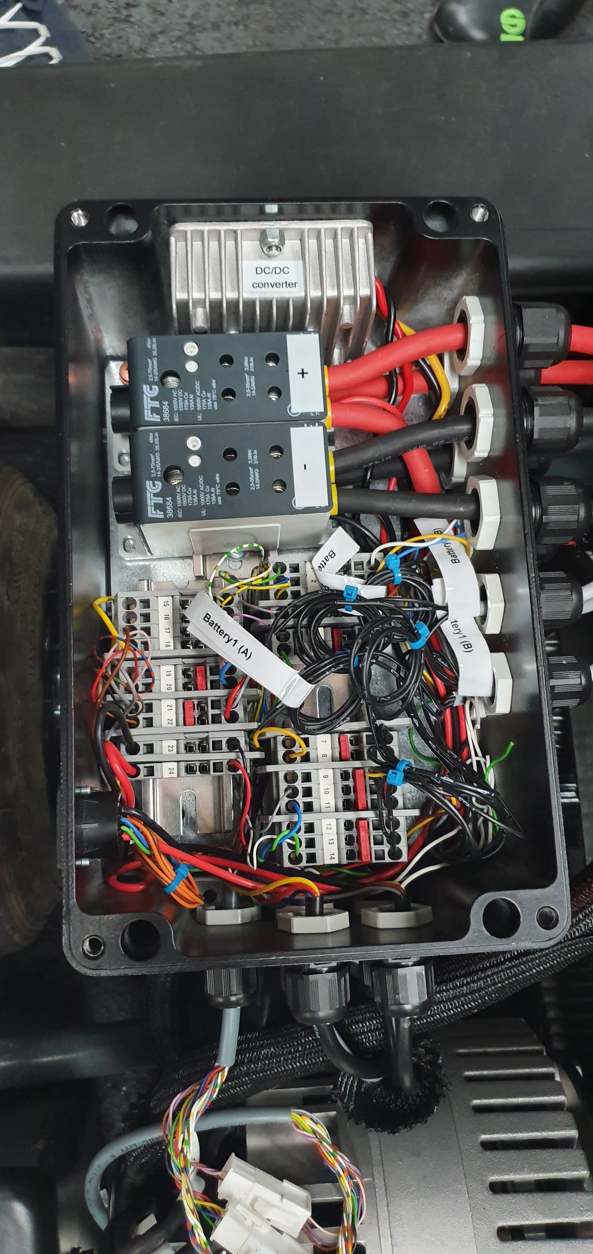 A close up of a fuse box with a lot of wires coming out of it.