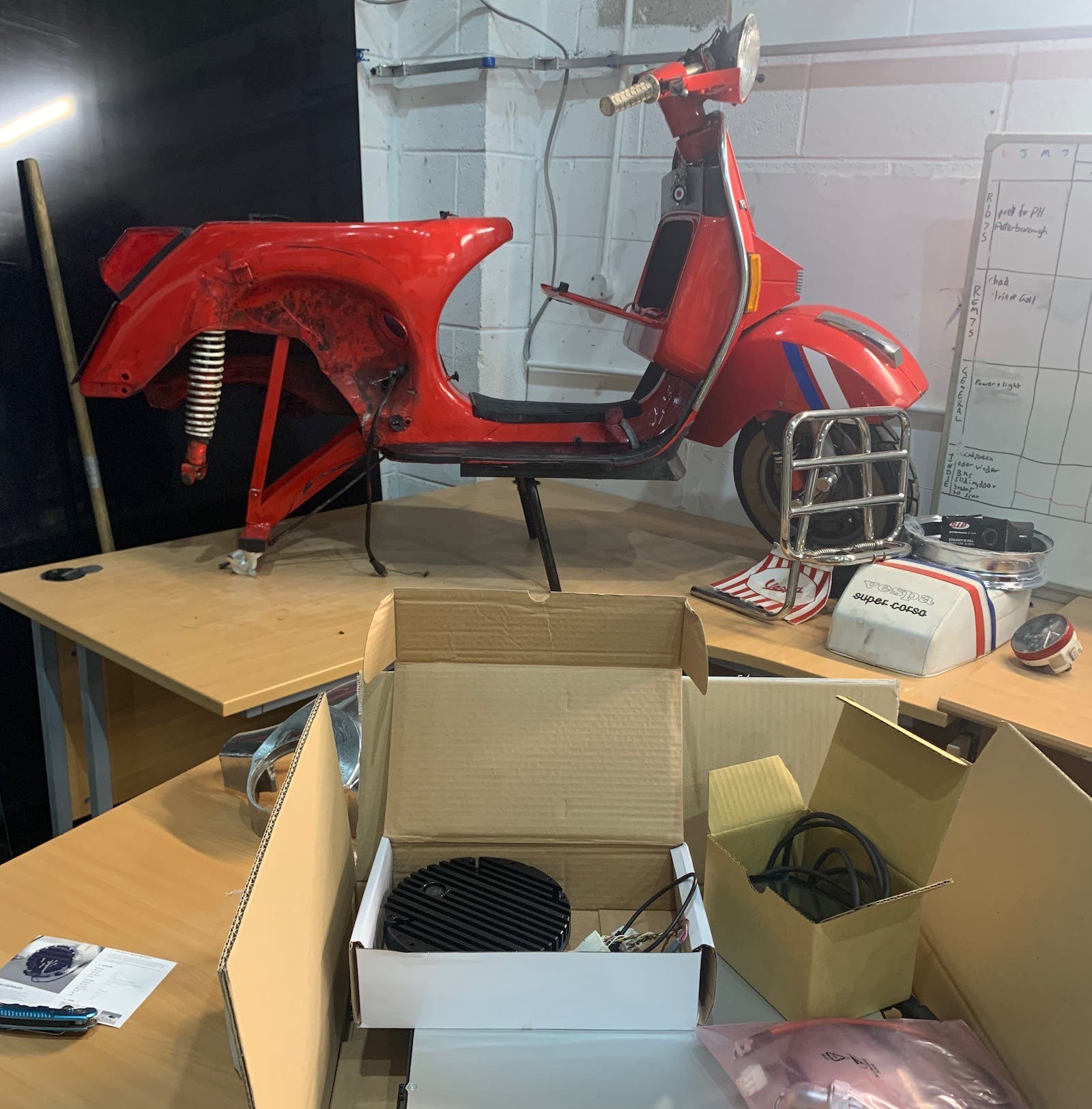 A red scooter is sitting on top of a wooden table