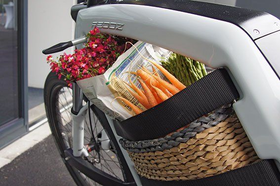 A bicycle with a basket full of carrots and flowers