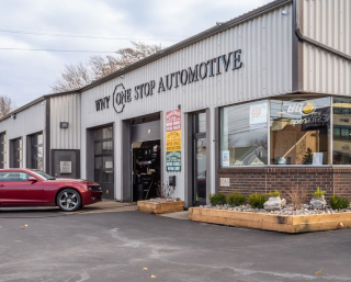 A red car is parked in front of why one stop automotive  | WNY One Stop Automotive