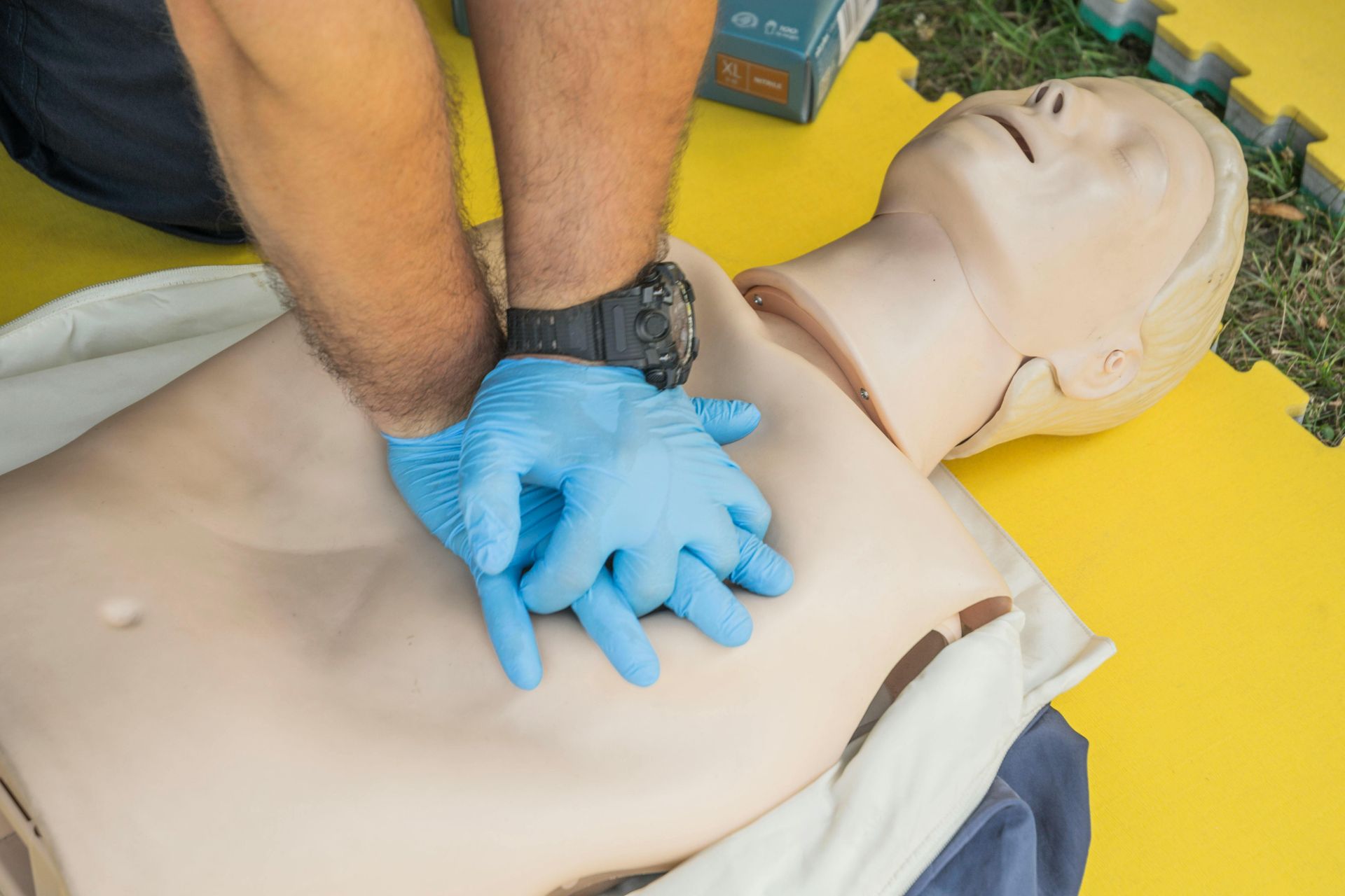 A man is doing a heart massage on a mannequin.