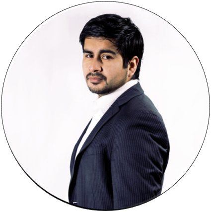 Man in a navy blue suit and white shirt, looking over his shoulder against a white background.