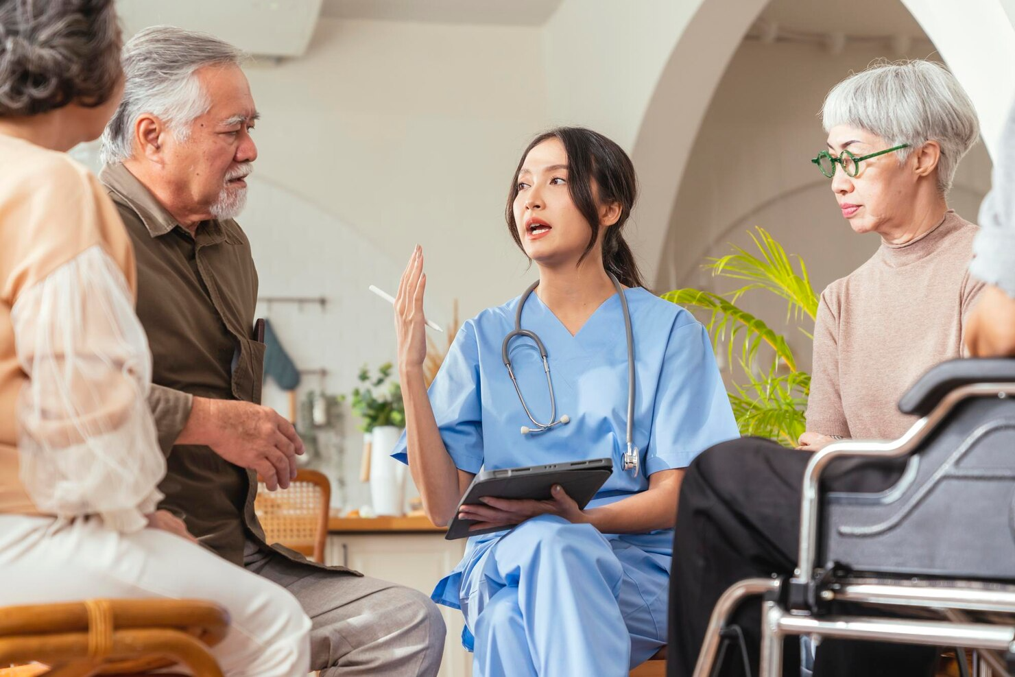 A nurse is talking to a group of elderly people.