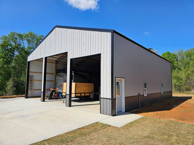 A large metal building with a trailer parked inside of it.