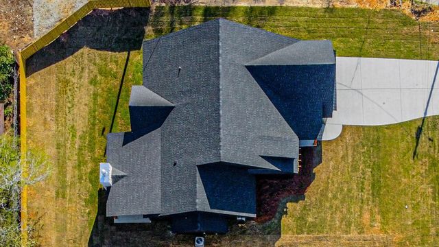 An aerial view of a house with a lot of grass and a driveway.