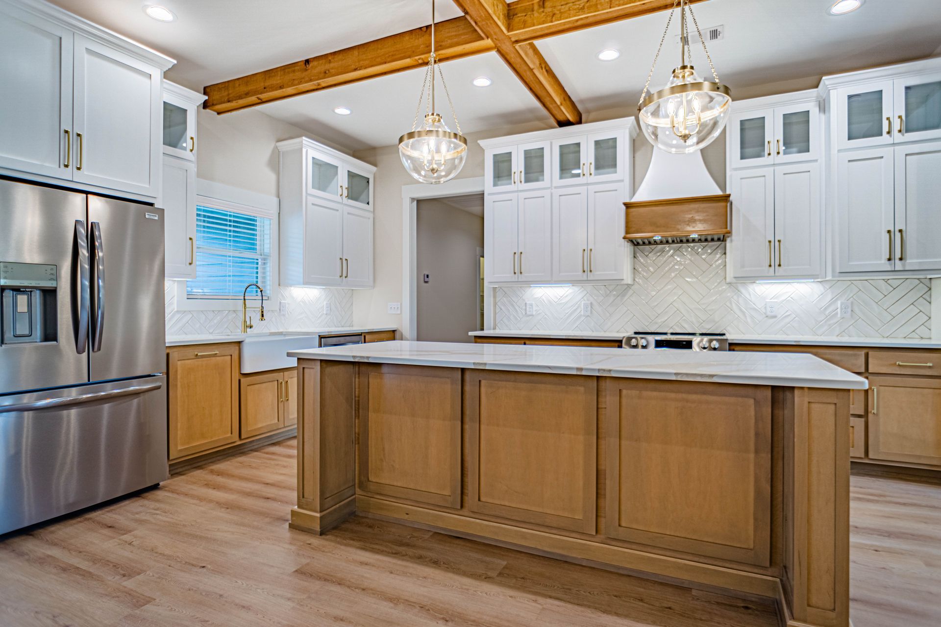 A kitchen with wooden cabinets , stainless steel appliances , and a large island.