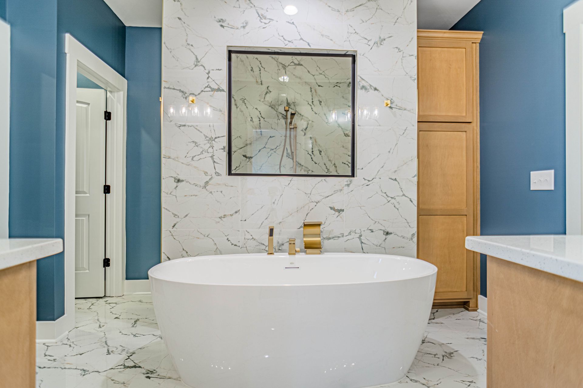 A bathroom with a bathtub and a mirror on the wall.