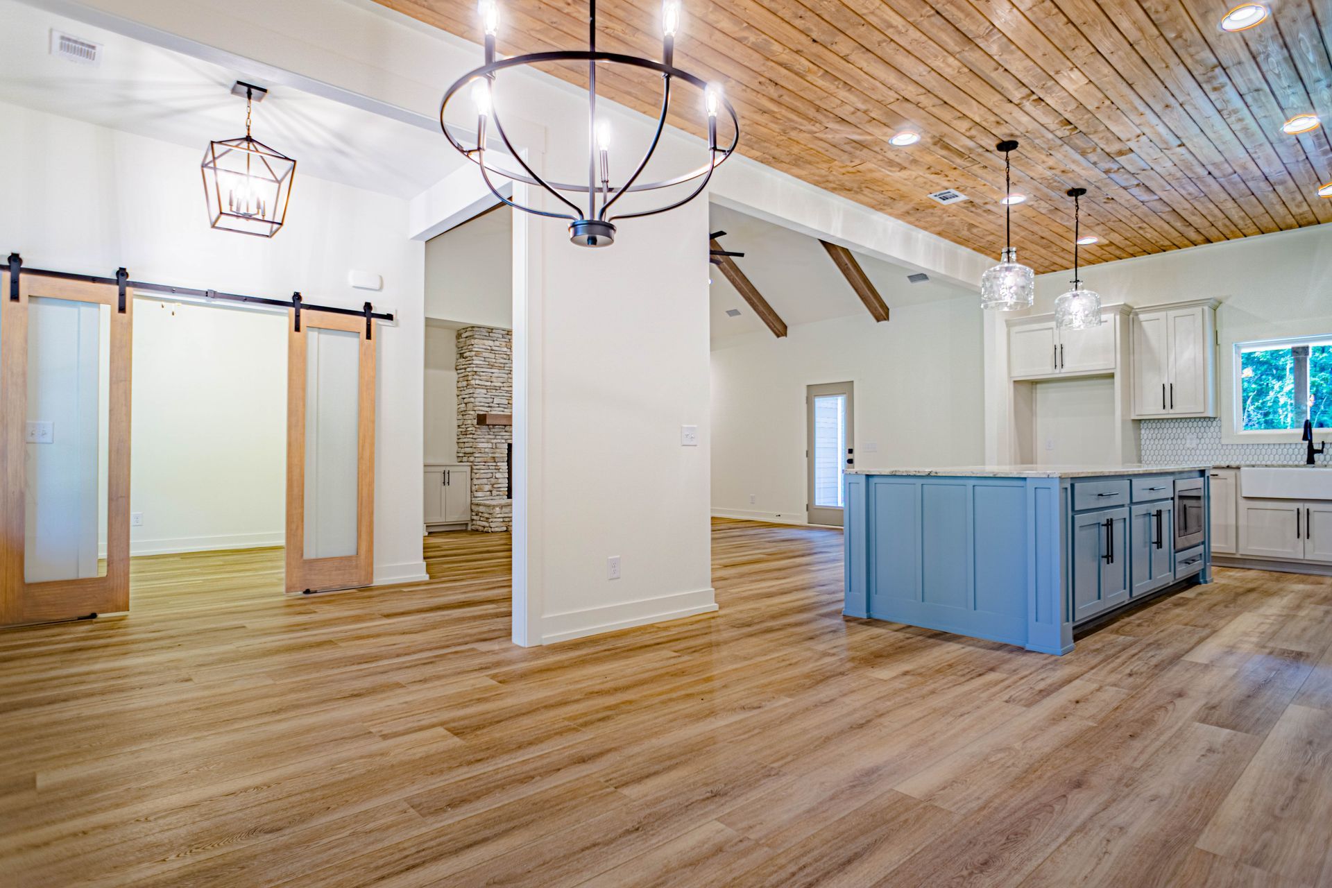A kitchen with a blue island and sliding barn doors.