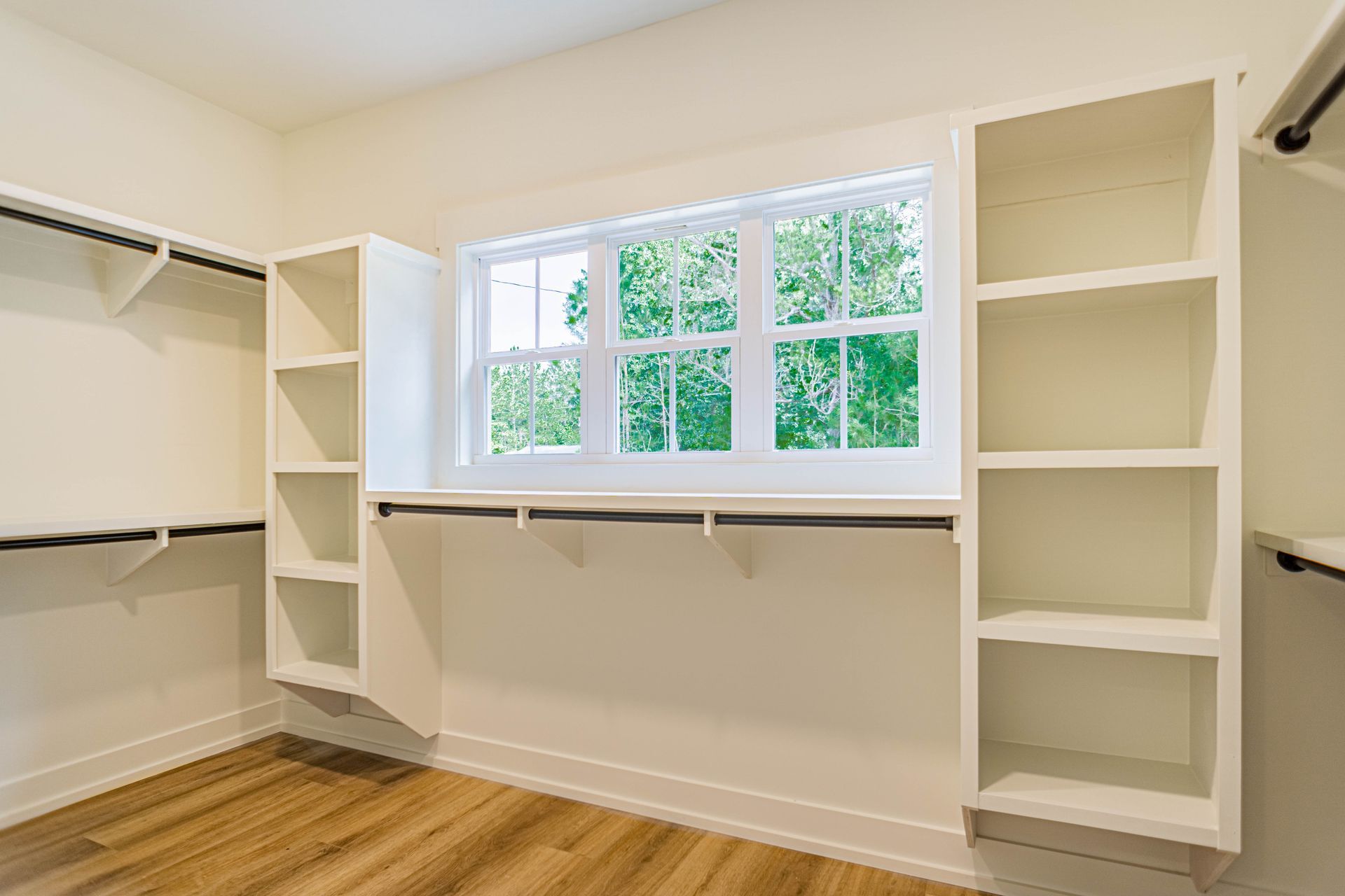 A walk in closet with lots of shelves and a window.