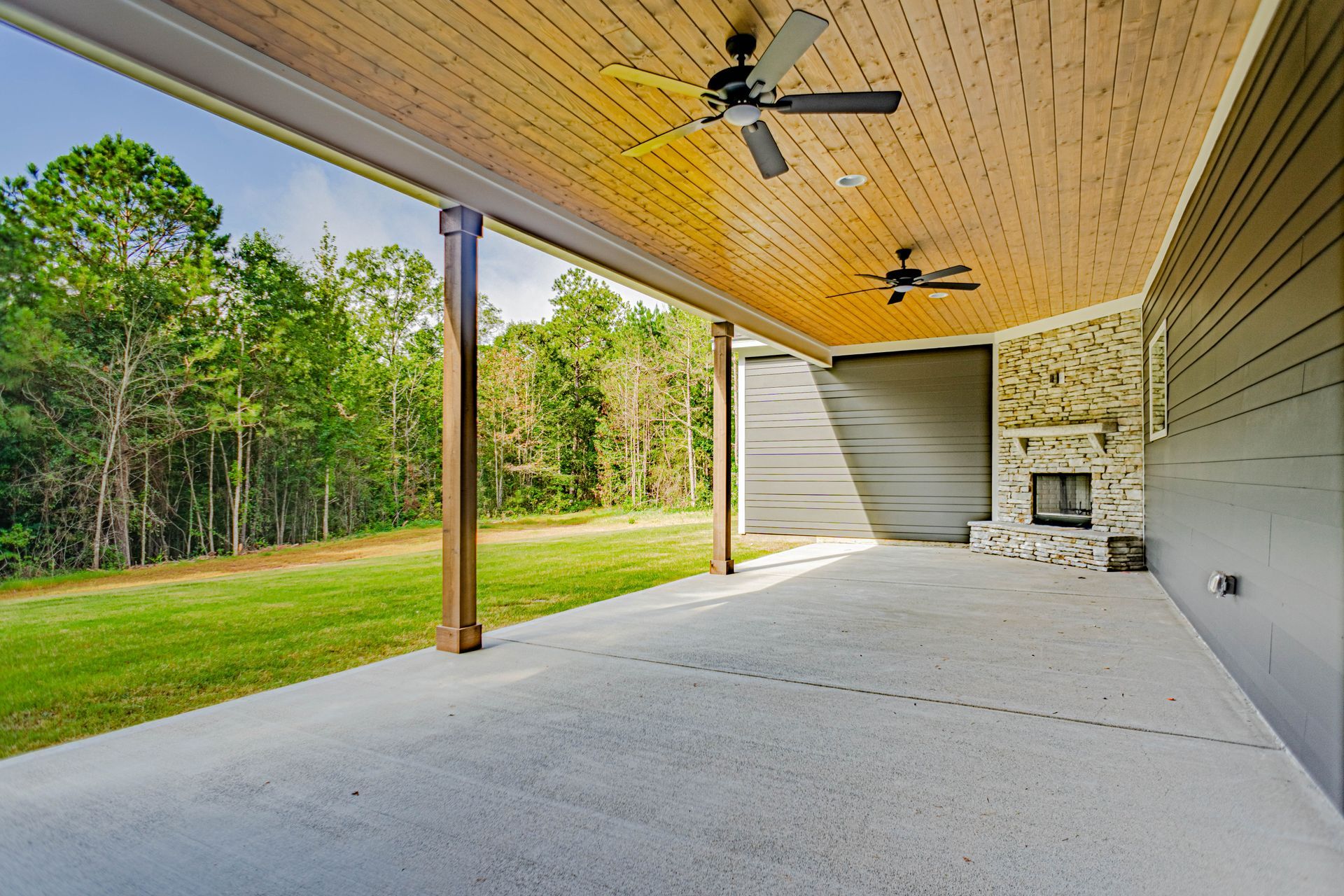 A covered patio with a ceiling fan and a fireplace