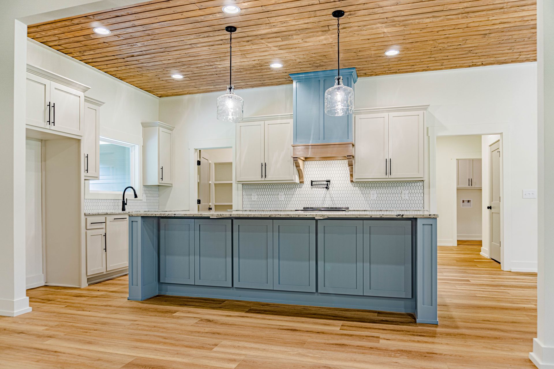 A kitchen with blue cabinets and a wooden ceiling.