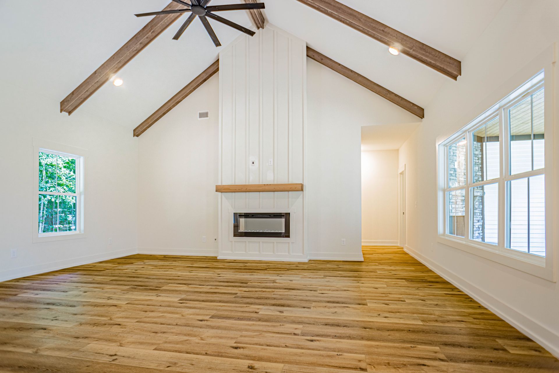 An empty living room with hardwood floors and a fireplace.