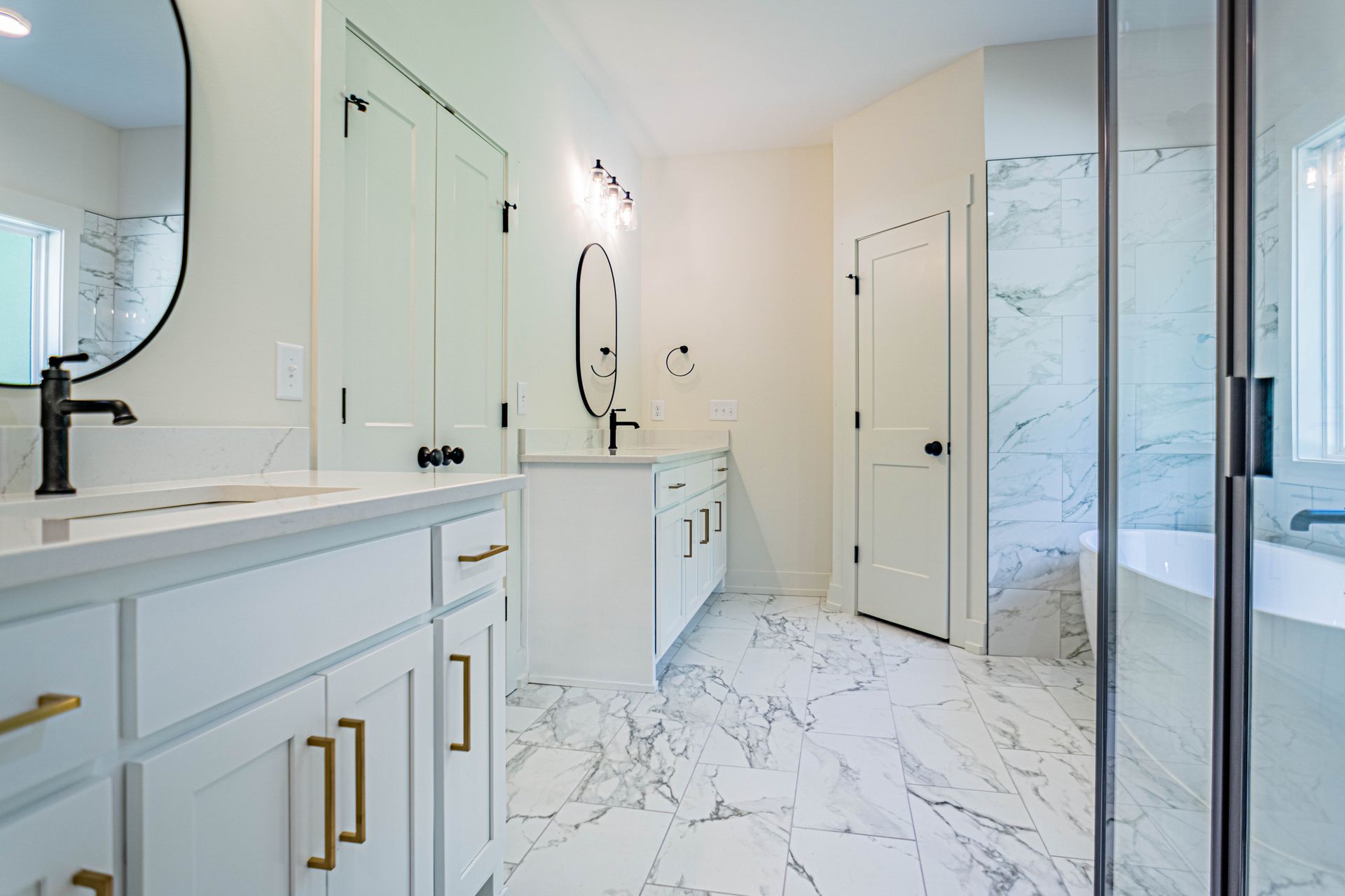 A bathroom with two sinks , a mirror and a tub.
